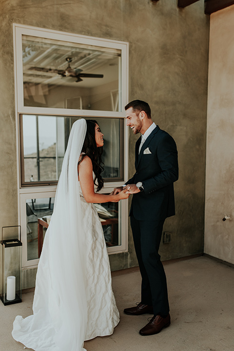 Dragon-point-villa-wedding-bride-and-groom-first-look-bride-in-a-white-ball-gown-with-sleeves-and-straps-groom-in-a-slim-black-suit-with-a-white-tie