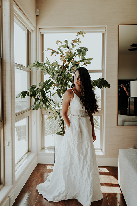 Dragon-point-villa-wedding-bride-with-hand-in-pocket-in-a-white-ball-gown-with-pockets-and-thin-straps