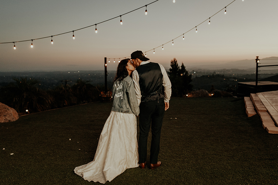 Dragon-point-villa-wedding-bride-with-jean-jacket-groom-with-hat-bride-in-a-white-ballgown-with-pockets-and-thin-straps-and-a-jean-jacket-groom-in-a-black-suit-with-a-white-tie