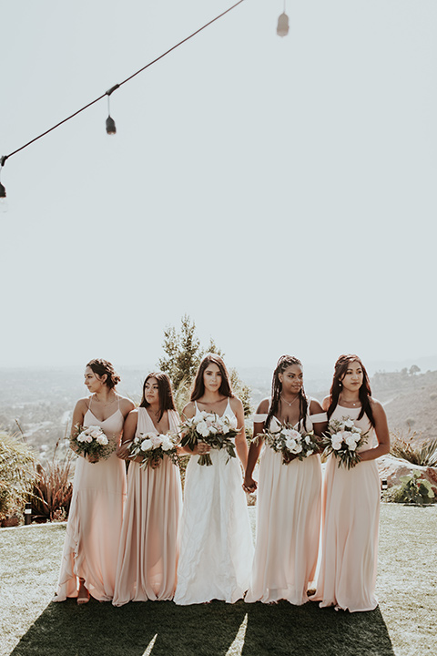 Dragon-point-villa-wedding-bridesmaids-looking-serious-bride-in-a-white-ball-gown-with-pockets-and-thin-straps-bridesmaids-in-long-blush-dresses