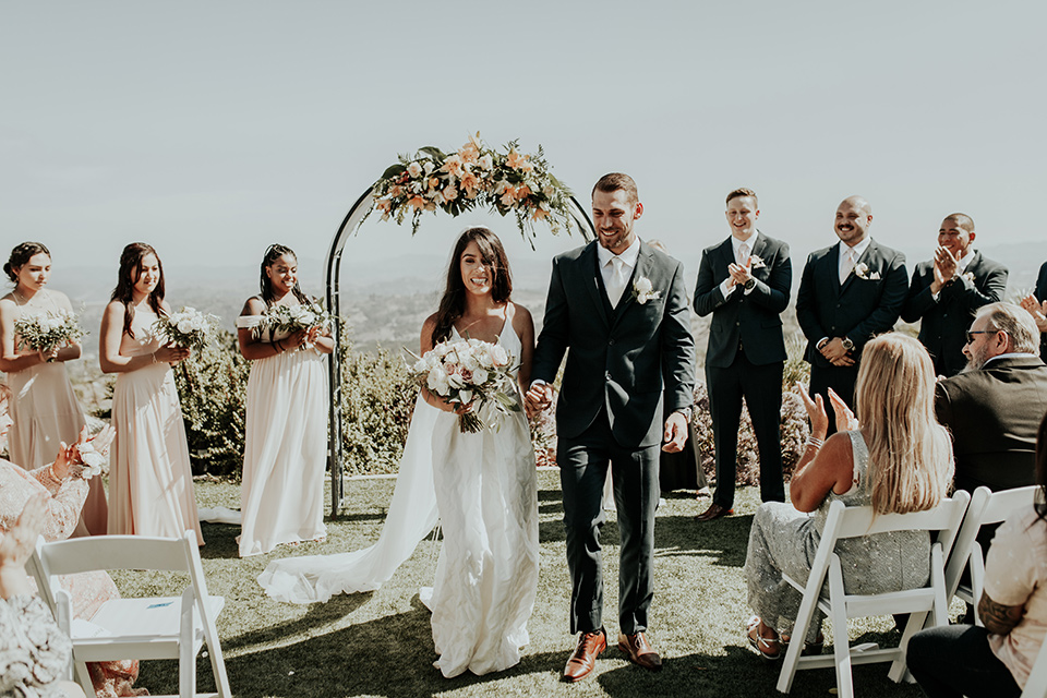 Dragon-point-villa-wedding-ceremony-bride-in-a-white-ballgown-with-pockets-and-thin-straps-groom-in-a-black-suit-with-a-white-tie