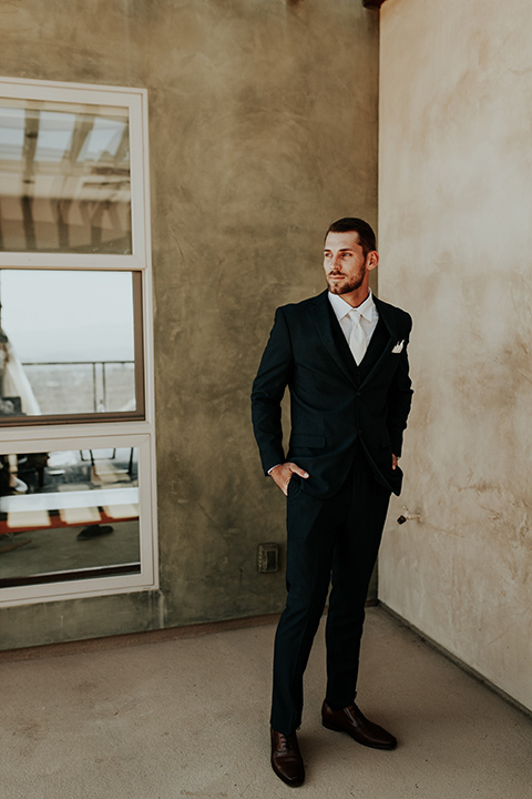 Dragon-point-villa-wedding-groom-standing-on-balcony-in-a-black-suit-and-white-tie