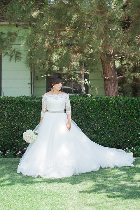 Elements-Venue-presents-wedding-bride-holding-flowers-in-a-layered-tulle-ball-gown-with-a-high-neckline-and-quarter-sleeves