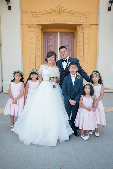 Elements-Venue-presents-wedding-flower-girls-and-ringbarers-in-pink-gowns-ringbarers-in-navy-suits-with-pink-long-ties-bride-is-in-a-layered-tulle-ball-gown-with-a-high-neckline-and-quarter-sleeves-groom-in-a-navy-blue-shawl-lapel-tuxedo-with-a-black-bow-tie