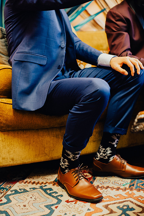 disco style wedding photo of man's feet with blue suit pants and floral socks