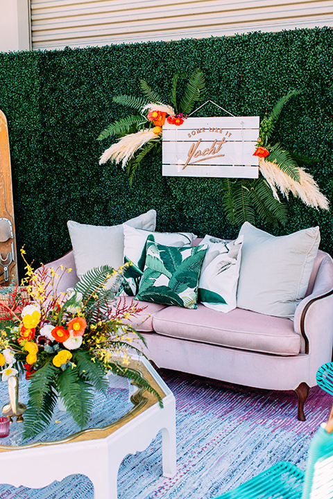 Disco style wedding outside furniture with a light pink retro inspired couch and tropical like decor