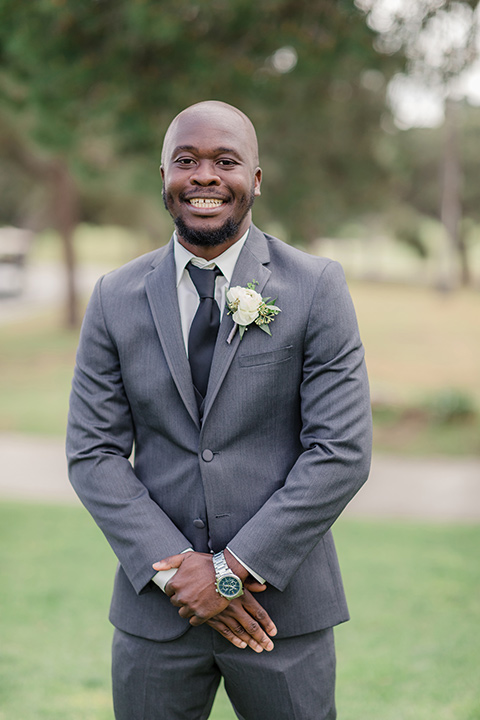 Los-Verdes-Golf-Course-Wedding-groom-smiling-at-camera-in-a-white-gown-with-cap-sleeves-groom-in-a-charcoal-tuxedo-with-a-black-tie