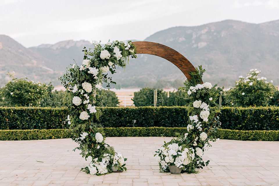  rounded ceremony arch with flowers on it 