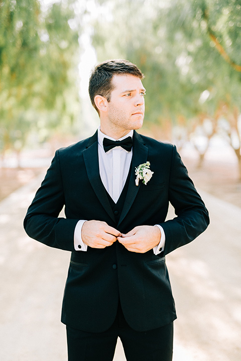  groom in a black tuxedo with a black bow tie