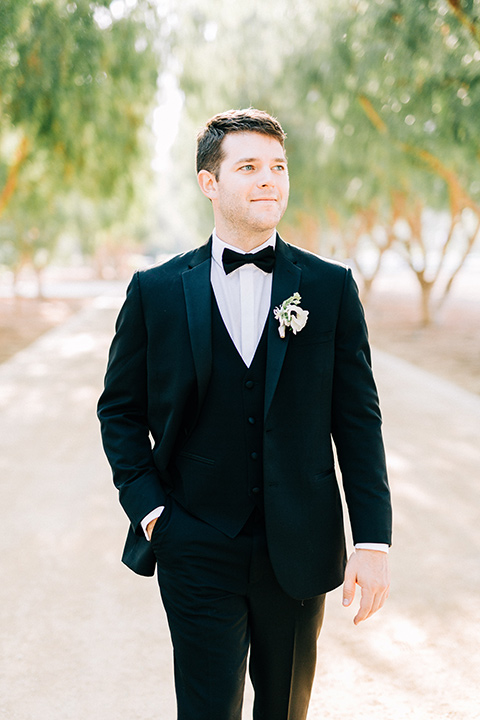  groom in a black tuxedo with a black bow tie 