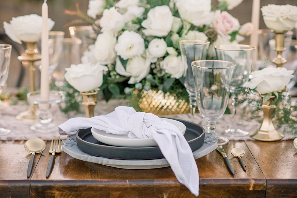 wooden table with white flatware and white florals 