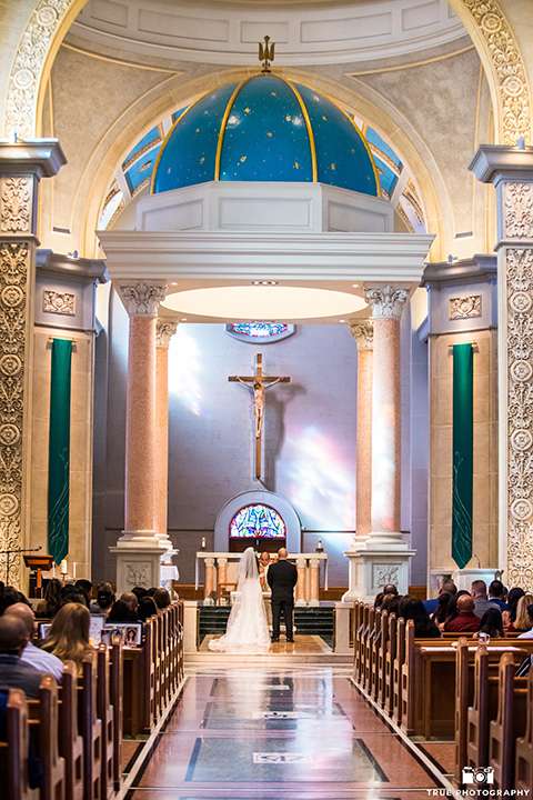 San-Diego-Wedding-ceremony-bride-in-a-white-lace-gown-with-an-off-the-shoulder-neckline-groom-is-in-a-black-tuxedo-with-a-black-bow-tie