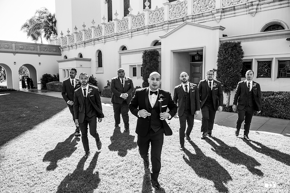 San-Diego-Wedding-groomsmen-standing-in-a-triangle-in-cobalt-suits-and-the-groom-is-in-a-black-tuxedo-with-a-black-bow-tie