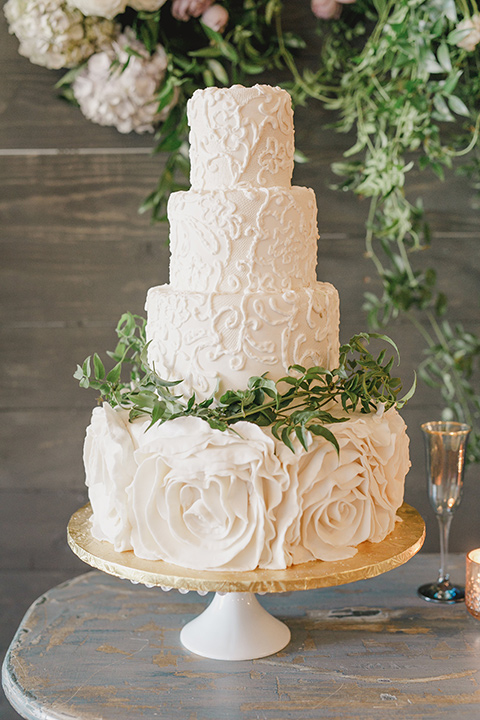 white three tiered cake with green leaf detailing