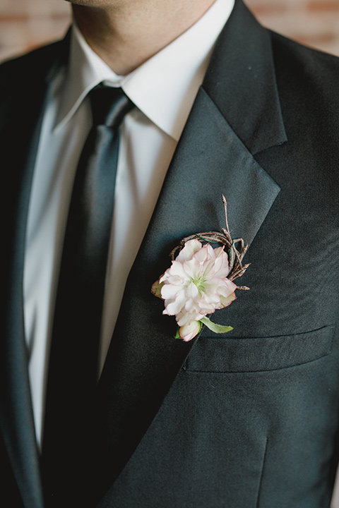 black tuxedo with a notch lapel and a black long tie