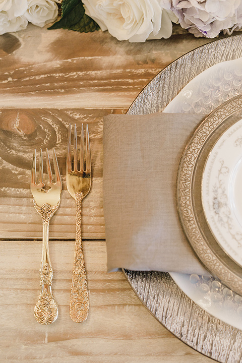 white plates with gold trim and gold flatware