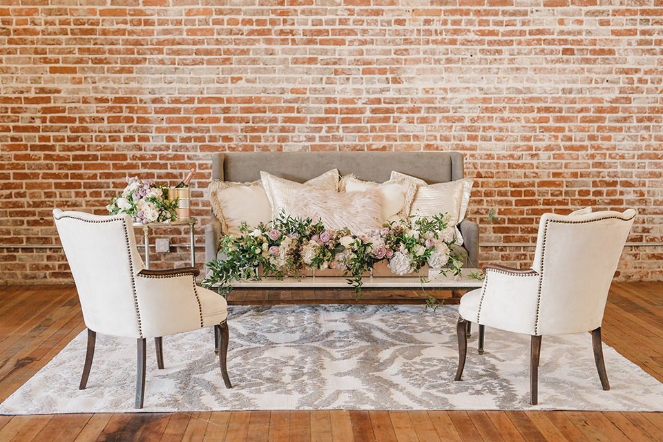 white couch with a white carpet and white and pink flowers everywhere