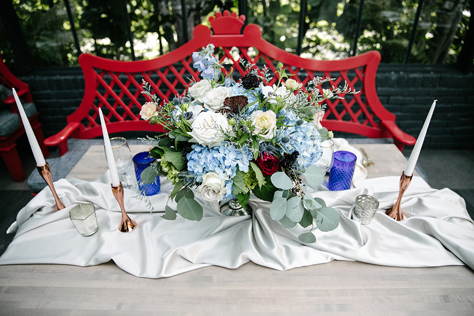 Red chair with white linens and tall white candles