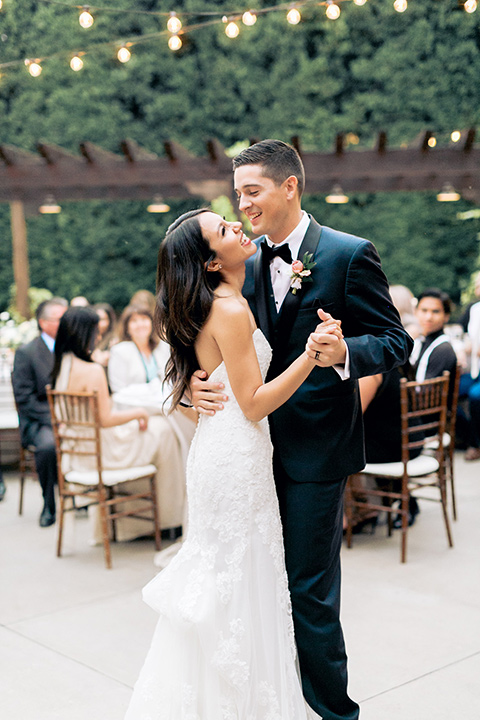 franciscan-gardens-wedding-bride-and-groom-dancing-bride-in-a-mermaid-white-strapless-gown-with-hair-down-in-a-simple-wave-and-groom-in-a-dark-blue-tuxedo-with-a-black-shawl-lapel-and-black-bow-tie