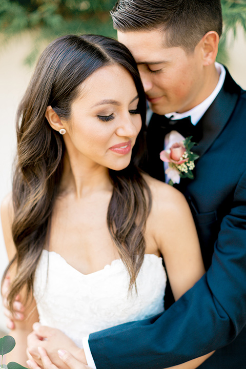 franciscan-gardens-wedding-close-up-of-bride-and-groom-bride-in-a-mermaid-white-strapless-gown-with-hair-down-in-a-simple-wave-and-groom-in-a-dark-blue-tuxedo-with-a-black-shawl-lapel-and-black-bow-tie