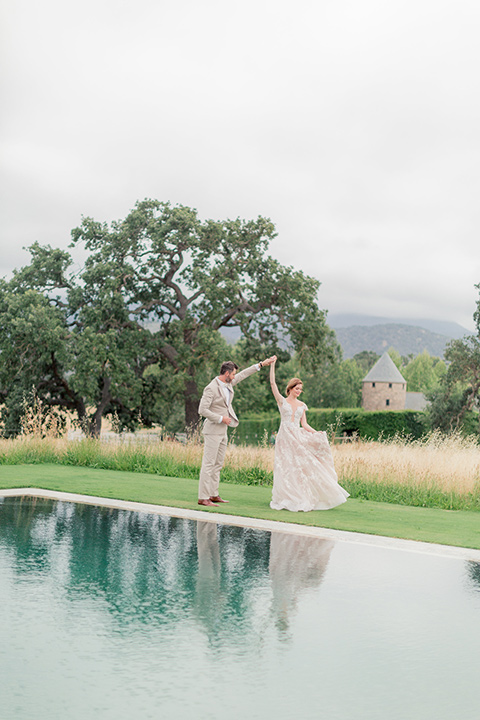 bride and groom twirling by the pond at the venue