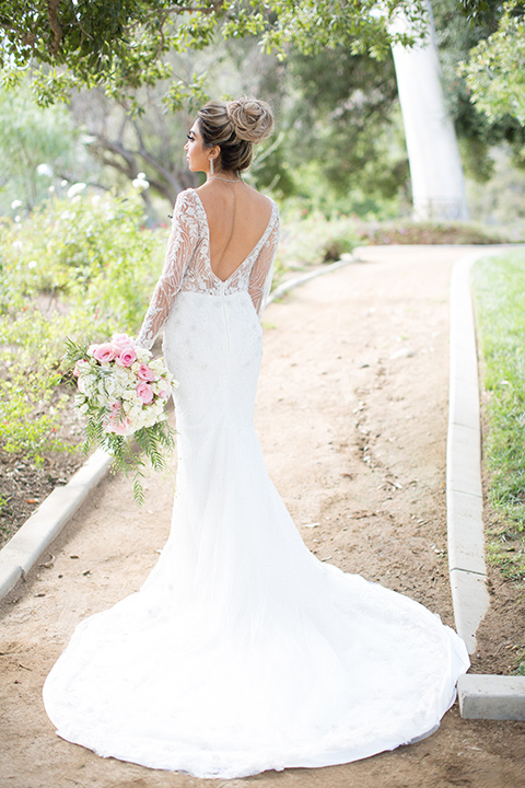 bride in a long sleeved gown with a satin underlay and hair up in a top knot bun