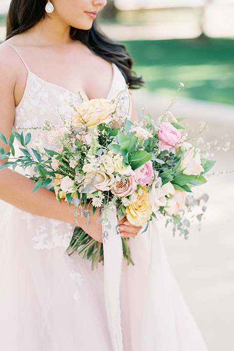 bride in a blush colored gown with thin straps and a sweetheart neckline