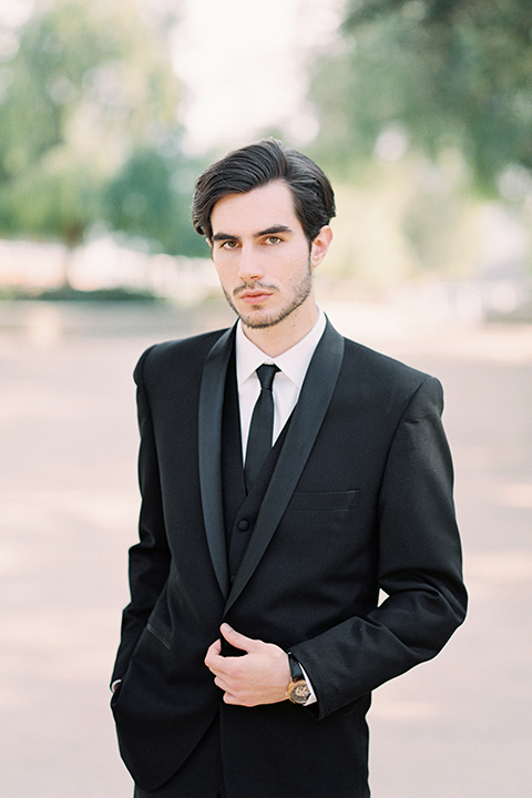  groom in a black shawl lapel tuxedo with a black long tie