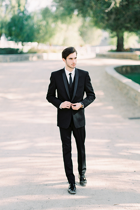 groom in a black shawl lapel tuxedo with a black long tie