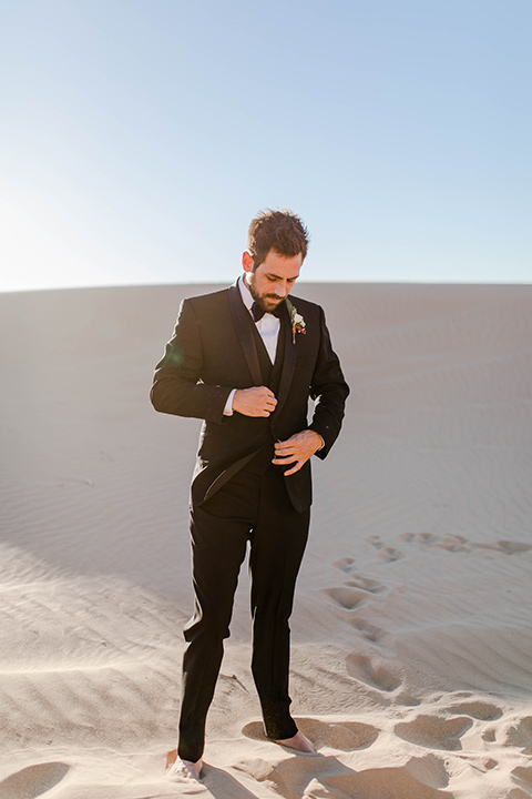 Glamis-Engagement-Shoot-Groom-alone-wearing-a-black-tuxedo-with-a-velvet-bow