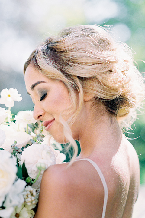 bride wearing a tulle ballgown with thin straps and her hair in a loose braided bun