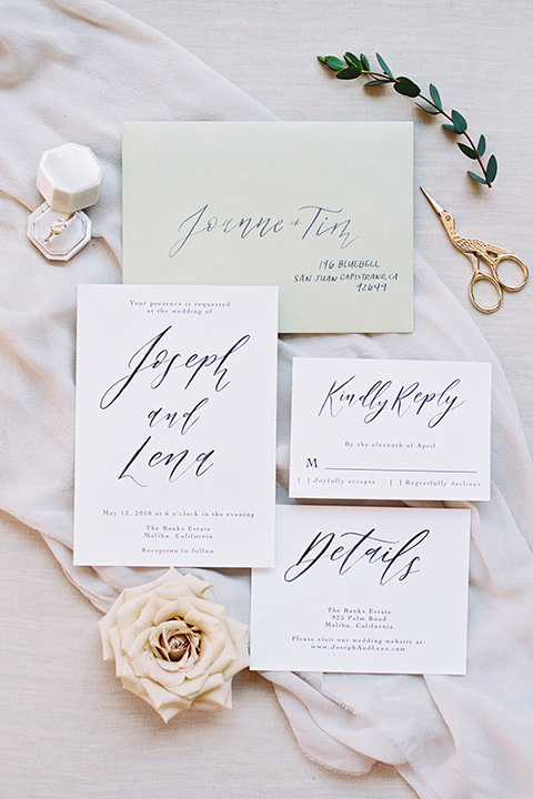  white invitations with calligraphy and pink flowers