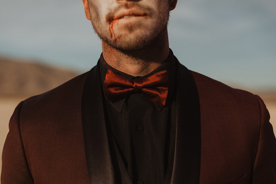 Halloween-Shoot with the groom in a burgundy tuxedo with a black shirt and burgundy bow tie