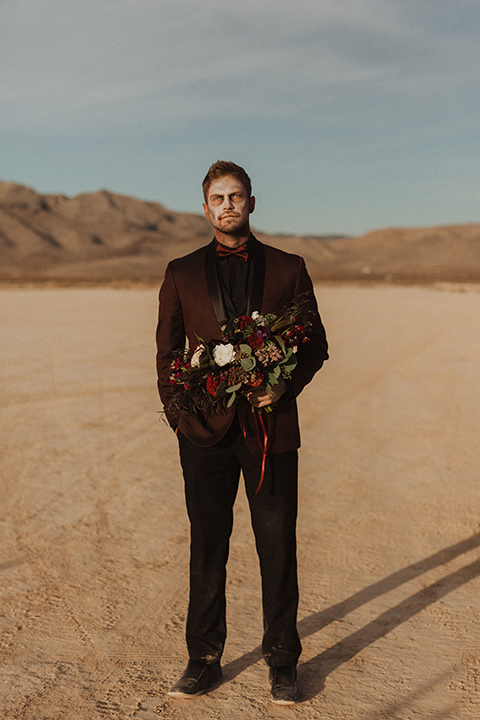 Halloween shoot with the groom is in a burgundy tuxedo with a black shirt and burgundy bow tie