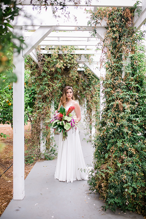  the bride in a boho style gown with straps and a bright colored floral headband