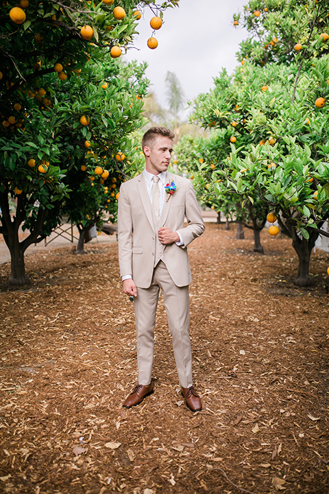  the groom in a tan suit with a tan long tie