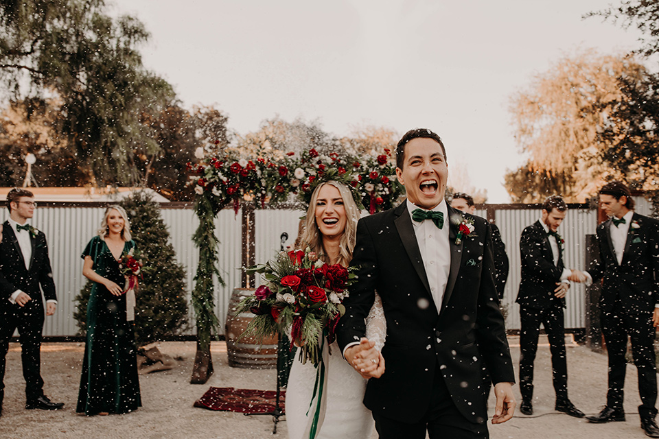 Highway-West-Vacations-bride-and-groom-with-snow-bride-in-a-lace-bohemian-dress-with-sleeves-and-floral-crown-groom-in-a-black-tuxedo