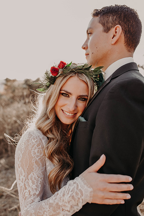 Highway-West-Vacations-bride-on-grooms-chest-bride-alone-in-a-lace-gown-with-sleeves-and-a-floral-crown-groom-in-a-black-tuxedo-with-a-velvet-bow-tie