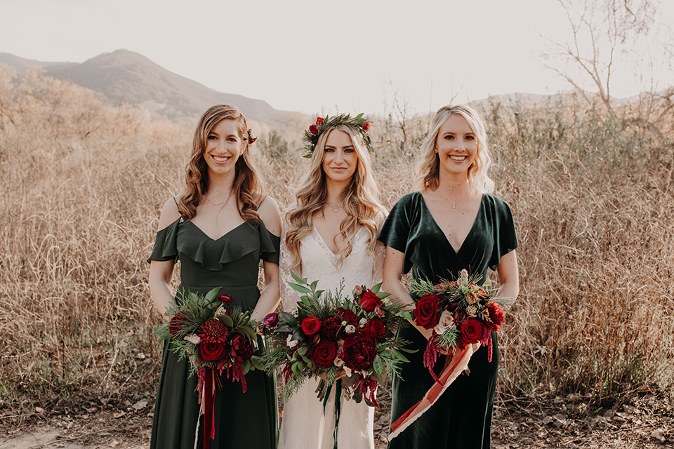 Highway-West-Vacations-bridesmaids-in-deep-green-dresses-bride-in-a-long-sleeved-lace-gown-with-a-floral-crown