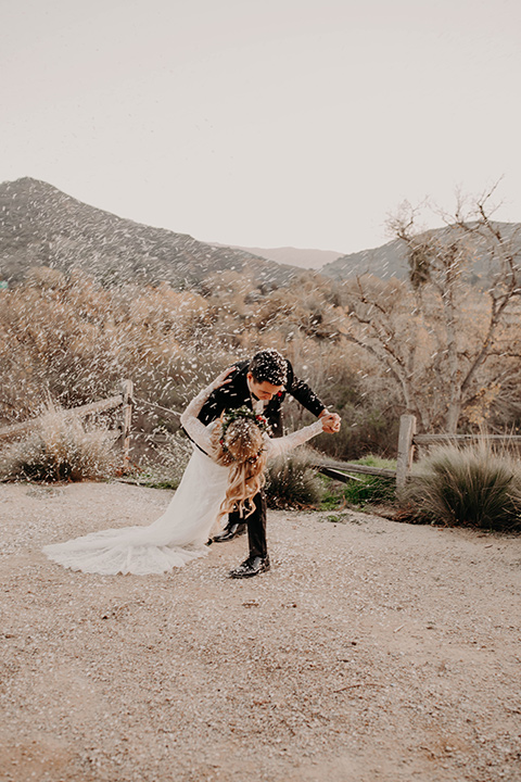 Highway-West-Vacations-groom-dipping-bride-groom-alone-in-a-black-tuxedo-with-a-velvet-bow-tie-in-a-white-lace-down-with-sleeves