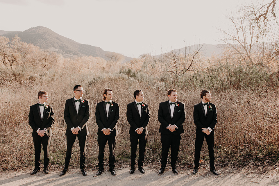 Highway-West-Vacations-groomsmen-in-black-tuxedos-with-velvet-bow-ties