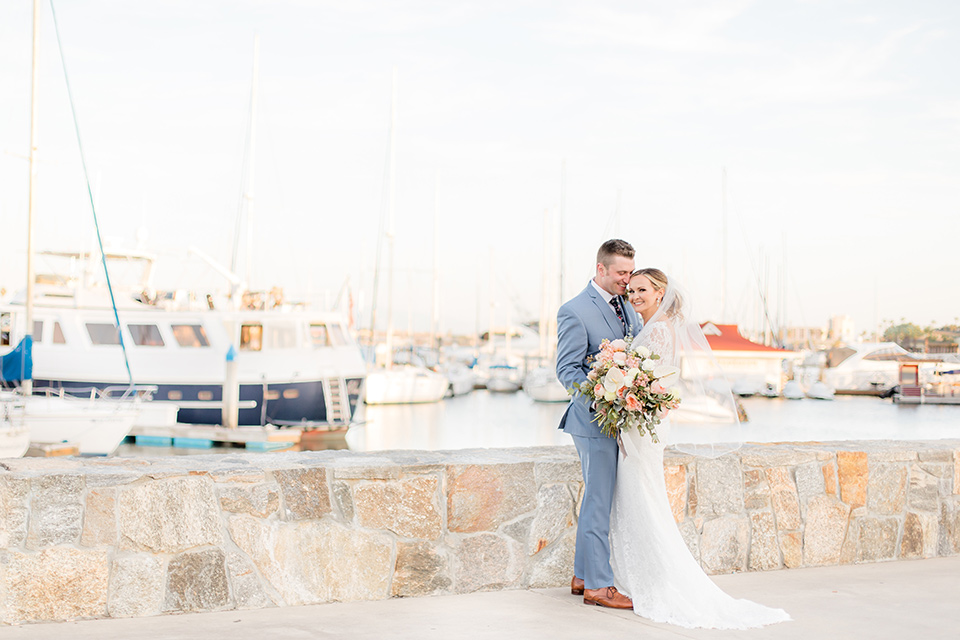 Bride and groom pose in front of the Coronado Harbor