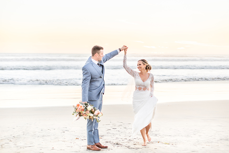 Bride and groom dance on the beach in their outfits