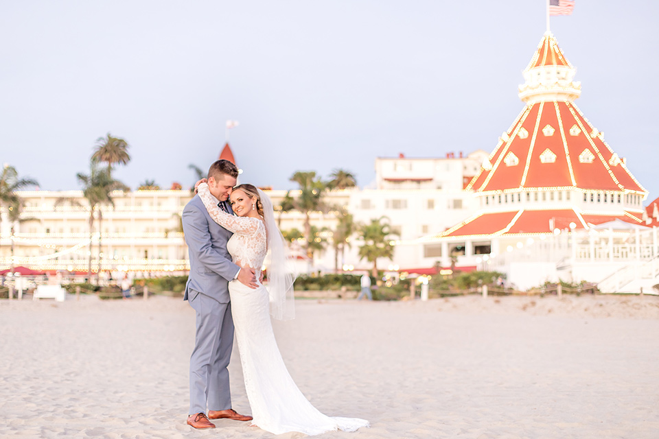 Bride and groom pose for a wedding photo in front of the Hotel Del Coronado