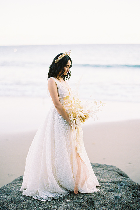  bride in a cream colored bohemian inspired gown with a gold crown 