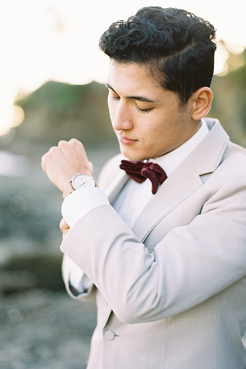  groom in a tan suit with a burgundy velvet bow tie