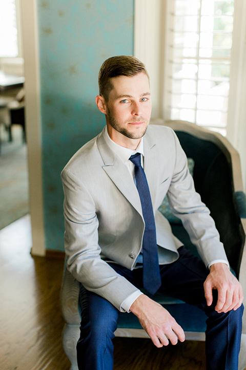  groom in a light grey suit coat with dark blue pants and a long tie