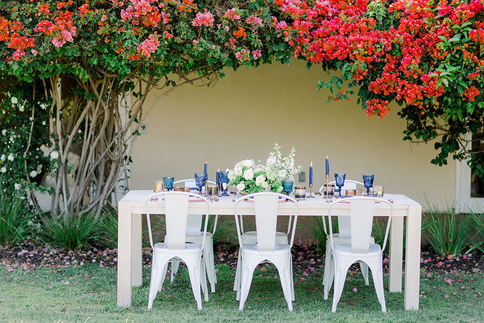 white table with white farmer chairs and blue and blush décor and flatware