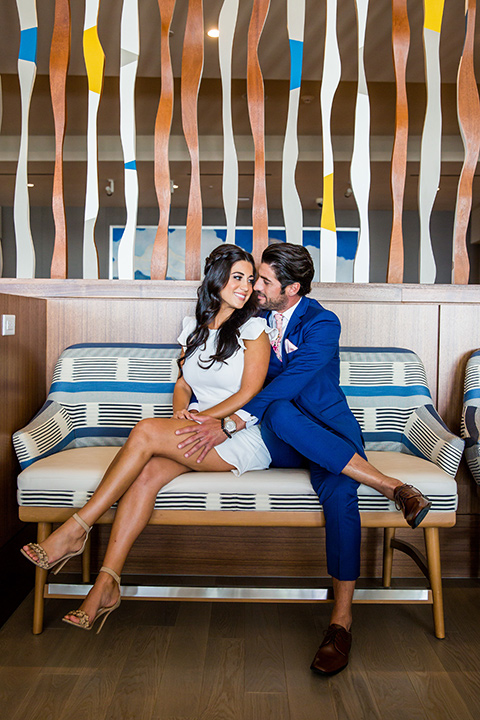 Intercontinental-elopement-shoot-bride-and-groom-on-the-couch-bride-in-a-short-dress-with-straps-groom-in-a-cobalt-blue-suit-with-floral-tie