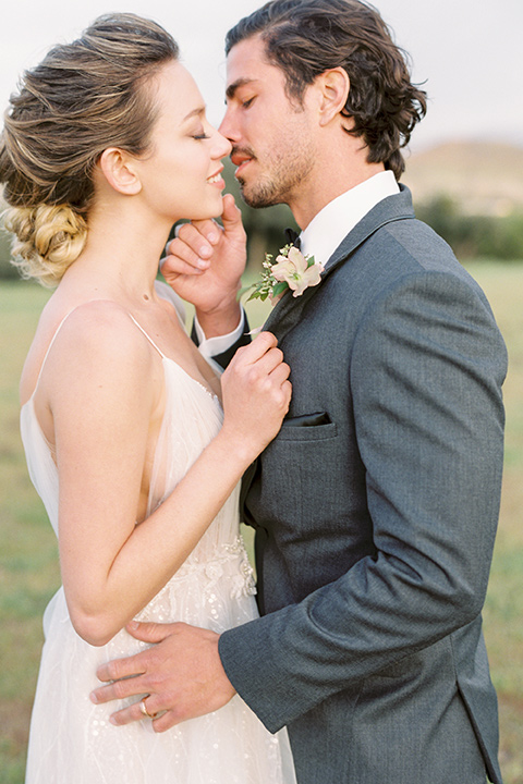 italian-style-wedding-bride-and-groom-close-up-almost-kissing-bride-in-a-flowing-gown-with-straps-and-her-hair-up-groom-in-a-grey-tuxedo